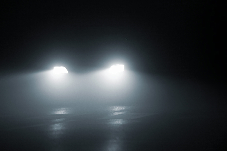 Bil kører med tågelys om natten